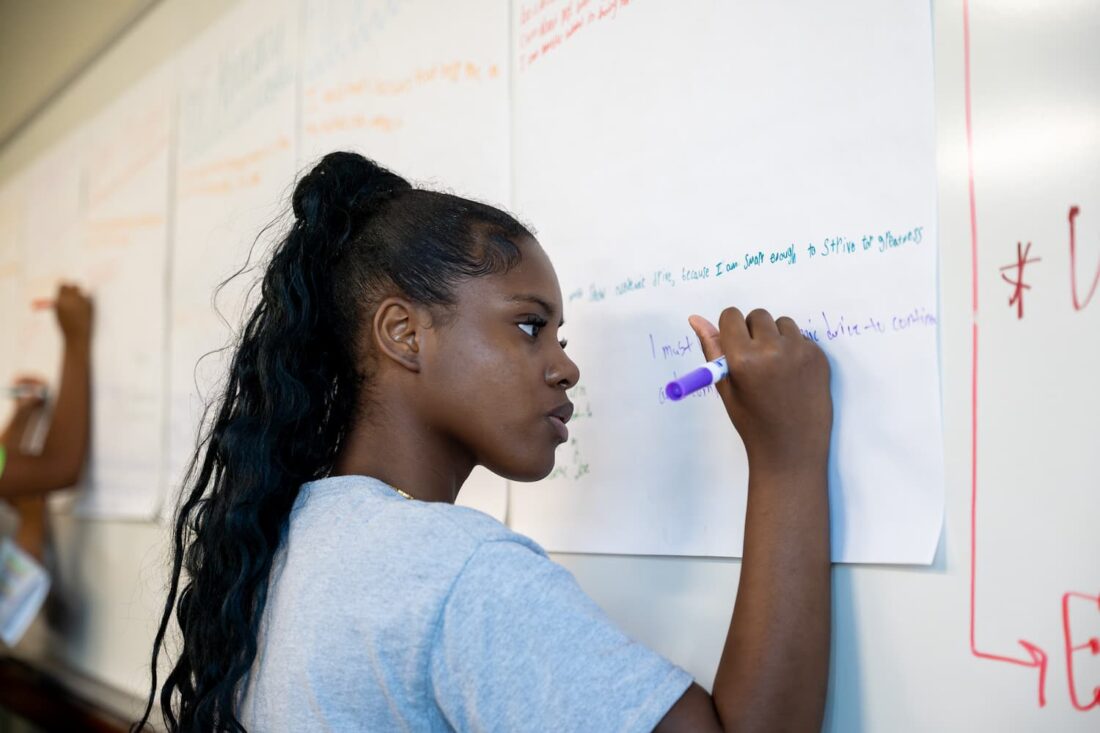 student writing on white board