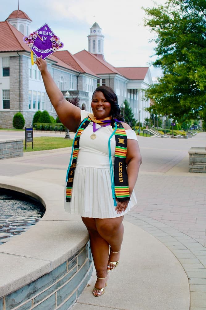 graduating student holding up their cap and smiling